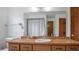 Bathroom with vanity, sink, and large mirror, white walls, and wood accents at 5891 Sir Henry Rd, Orlando, FL 32808