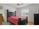 Bright bedroom features hardwood floors, ceiling fan, and a large black bed with a patterned bedspread at 5891 Sir Henry Rd, Orlando, FL 32808