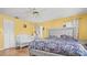 Bedroom with yellow walls, wood floors, a large silver headboard, a crib, and curtains at 5891 Sir Henry Rd, Orlando, FL 32808