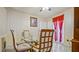 Warm dining area featuring a glass top table, upholstered chairs, and bright window curtains at 5891 Sir Henry Rd, Orlando, FL 32808