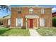 Charming brick two-story home featuring a bright red front door and white window shutters at 5891 Sir Henry Rd, Orlando, FL 32808