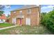Two-story brick home with a red front door and white shutters, surrounded by a green lawn at 5891 Sir Henry Rd, Orlando, FL 32808