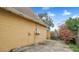 Exterior view of the home with a concrete area, adjacent to the yard at 5891 Sir Henry Rd, Orlando, FL 32808