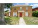 Two-story brick home with a red front door and white shutters at 5891 Sir Henry Rd, Orlando, FL 32808