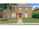 Charming two-story brick house with well-manicured front yard and a red front door at 5891 Sir Henry Rd, Orlando, FL 32808