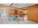 Open living room with tile flooring, wood paneling, and a view into the kitchen at 5891 Sir Henry Rd, Orlando, FL 32808