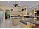 Bright kitchen featuring an island, granite countertops, tiled floors, and modern stainless steel appliances at 6092 Sabal Hammock Cir, Port Orange, FL 32128
