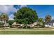 Charming home featuring a lush green lawn and mature trees, including palms, creating a serene outdoor space at 6226 Wynfield Court, Orlando, FL 32819