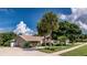 Well-maintained home featuring palm trees, mature trees, and a lush green lawn at 6226 Wynfield Court, Orlando, FL 32819