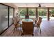 Covered and screened in patio featuring a ceiling fan and table with seating overlooking the pool at 6226 Wynfield Court, Orlando, FL 32819