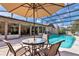 Outdoor pool area with an umbrella, glass table, and patio seating for outdoor relaxation and entertainment at 6226 Wynfield Court, Orlando, FL 32819