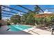 This home features a screened-in pool area with clear blue water, seating and a sunshade at 6226 Wynfield Court, Orlando, FL 32819