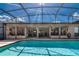 The crystal blue swimming pool has a screened enclosure and a covered patio for entertaining at 6226 Wynfield Court, Orlando, FL 32819