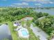 Aerial view of a community clubhouse and pool, plus tennis courts, by a lake at 6630 Hidden Beach Cir, Orlando, FL 32819