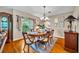 Elegant dining room with hardwood floors, a classic chandelier, and ample natural light from the large window at 6630 Hidden Beach Cir, Orlando, FL 32819