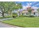 Charming single-story home boasts a well-manicured lawn, flowering tree, and mature landscaping at 6630 Hidden Beach Cir, Orlando, FL 32819