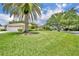 Spacious front yard showcasing a well-maintained lawn, mature palm tree, and inviting curb appeal at 6630 Hidden Beach Cir, Orlando, FL 32819
