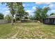 Spacious backyard with a new fence, mature trees, a hammock, and a lush green lawn; perfect for outdoor activities at 705 Ibis Ave, Deltona, FL 32738