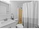 Clean bathroom features a modern vanity, toilet, and a shower with striped curtain at 705 Ibis Ave, Deltona, FL 32738