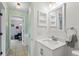 Clean bathroom features a modern vanity, toilet, and a shower with a striped curtain at 705 Ibis Ave, Deltona, FL 32738