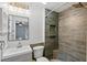 Updated bathroom featuring a modern vanity, toilet, and a stylish walk-in shower with wood-look tile and a built-in niche at 705 Ibis Ave, Deltona, FL 32738