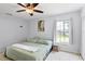 Cozy bedroom features tiled floors, a ceiling fan, a large window, and a closet at 705 Ibis Ave, Deltona, FL 32738