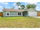 Inviting single-story home with a lush lawn and a convenient two-car garage at 705 Ibis Ave, Deltona, FL 32738