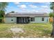 Exterior rear view showcasing solar panels, a screened porch, fresh paint, and a well-maintained yard at 705 Ibis Ave, Deltona, FL 32738