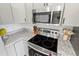 A well-equipped kitchen featuring a stainless steel range and microwave, plus stylish granite countertops at 705 Ibis Ave, Deltona, FL 32738