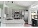 Bright kitchen with stainless steel appliances, grey cabinets, and granite countertops is move-in ready at 705 Ibis Ave, Deltona, FL 32738