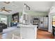 Spacious open-concept layout with the kitchen island in the foreground with living room featuring fireplace at 705 Ibis Ave, Deltona, FL 32738