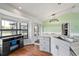 Modern kitchen featuring a gray cabinet island with barstool seating and sliding glass door to the backyard at 705 Ibis Ave, Deltona, FL 32738