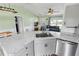 Modern kitchen with stainless steel appliances, a view to living and dining areas, and sleek granite countertops at 705 Ibis Ave, Deltona, FL 32738