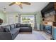 Inviting living room with a comfortable gray sectional sofa, electric fireplace, and large window for natural light at 705 Ibis Ave, Deltona, FL 32738