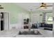 Cozy living room with comfortable grey sofa, ceiling fan, and convenient access to the front door at 705 Ibis Ave, Deltona, FL 32738