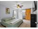 Main bedroom featuring a ceiling fan, an ensuite bathroom, and a sliding barn door at 705 Ibis Ave, Deltona, FL 32738