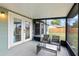The screened porch is equipped with a ceiling, stylish furniture, and an exterior door for easy access to the backyard at 705 Ibis Ave, Deltona, FL 32738