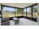 Relaxing screened porch features comfortable seating and views of the spacious backyard with a hammock and play set at 705 Ibis Ave, Deltona, FL 32738