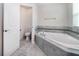 Elegant bathroom featuring a soaking tub with tiled surround, and a separate toilet room at 7530 Summerlake Groves St, Winter Garden, FL 34787