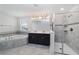 Luxurious bathroom features a glass-enclosed shower, soaking tub, double vanity, and tile flooring at 7530 Summerlake Groves St, Winter Garden, FL 34787