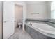 Bright bathroom with a corner soaking tub, tiled surround, and updated fixtures at 7530 Summerlake Groves St, Winter Garden, FL 34787