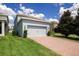 Charming blue single-Gathering home with an attached two-car garage and brick paver driveway at 7530 Summerlake Groves St, Winter Garden, FL 34787