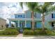 Charming two-story home with a welcoming front porch, lush landscaping, and beautiful palm trees at 7530 Summerlake Groves St, Winter Garden, FL 34787