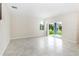Open-concept living room with light tile floors and sliding glass doors to the lanai at 7530 Summerlake Groves St, Winter Garden, FL 34787