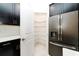 Pantry with plentiful wire shelving; stainless steel refrigerator in the adjacent kitchen at 7530 Summerlake Groves St, Winter Garden, FL 34787