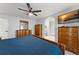 Spacious bedroom featuring wood furnishings, a ceiling fan, and a large TV for ultimate comfort and relaxation at 7764 Indian Ridge N Trl, Kissimmee, FL 34747