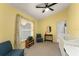 Bright bedroom with yellow walls, a large window with curtains, and comfortable seating at 7764 Indian Ridge N Trl, Kissimmee, FL 34747