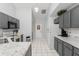 Charming kitchen features gray cabinets, marble countertops, and white tile floors at 7764 Indian Ridge N Trl, Kissimmee, FL 34747