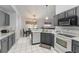 Open kitchen view, showing gray cabinets, white countertops, and stainless steel appliances at 7764 Indian Ridge N Trl, Kissimmee, FL 34747