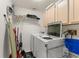 Well-equipped laundry room with a washer, dryer, and ample storage space at 7764 Indian Ridge N Trl, Kissimmee, FL 34747